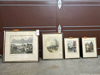 Four framed prints laid against wall showing relative sizes and scenes