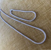 Necklace and bracelet laid out showing snake chain design