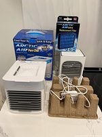Two cube-style Arctic Air coolers, boxed replacement filter, power cord visible