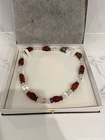 Necklace in display box, close view of bead arrangement and clasp