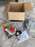 Turbocharger, box, accessories and instruction booklet on tiled floor