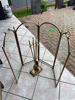 Full view of brass and glass folding screen with tool set inside