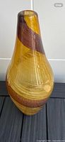 Full front view of elongated amber glass vase with brown spiral band