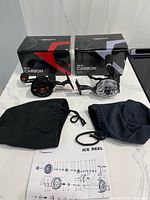 Two boxed Piscifun ICX Carbon reels with pouches and manual laid out
