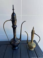 Both brass pitchers side by side showing size difference and design