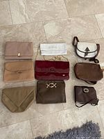 All eight purses laid out showing variety of styles, colours and sizes