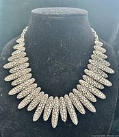 Front view of statement bib necklace on display bust