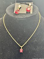 Necklace and earrings displayed together on stand