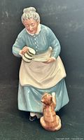 Front view of Royal Doulton figurine showing woman pouring milk to cat