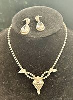 Necklace displayed on bust with earrings above, showing overall set