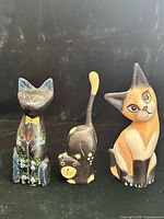 Front view of the three wooden cat figurines