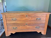 Front view showing two drawers, brass handles, keyholes, oak grain