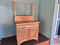 Front view of oak mission washstand showing drawer, doors, backsplash and towel rail
