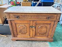 Front view of oak wash stand showing drawer, doors, hardware and marble top