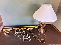 Overall view of table lamp, four picture lights, tape measure for scale