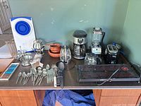 Overview of all appliances, bowls, flatware and utensils on tabletop