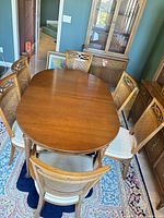Dining table with six chairs around it, china cabinet in background