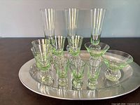 Entire set of 12 green bubble-base glasses arranged on stainless steel tray