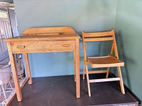 Front view of desk and folding chair together