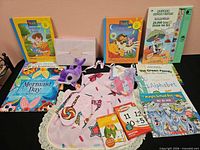 Overview of all items laid out: apron, plush dolphin, pillow sachet, books, flash cards