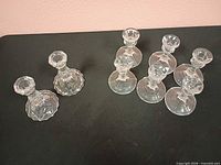 Group view of all eight glass candlestick holders showing two styles