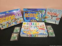 Group shot of four boxed board games and four sealed card packs
