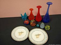 Full lot view showing plates, vases, bowl and paperweights