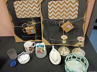 Overview of entire lot including basket, candlesticks, gravy boat, framed corkboards, mug, votive holders, dish, seed packets