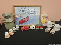 Group shot of entire lot showing sign, milk can, creamers with spoons, multiple shaker sets, figurines and books