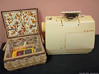 Sewing machine next to open wicker basket holding accessories