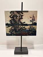 Front view on metal stand showing full artwork panel