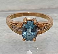 Front view showing blue topaz, prongs and shoulder detail