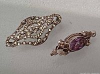 Both brooches side by side showing overall design and stones