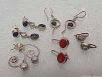 All five pairs of sterling silver earrings laid out to show styles and stones
