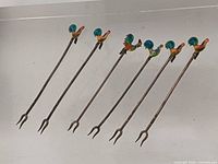 Six enamel rooster cocktail picks laid out