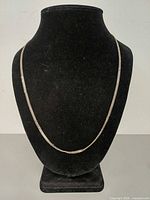 Full view of sterling silver curb chain necklace on display bust