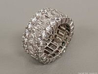 Three-quarter view of wide sterling silver ring showing two rows of round rhinestones and central baguette crystals