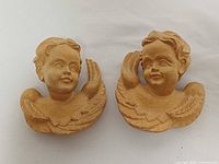 Front view of both carved wood cherubs