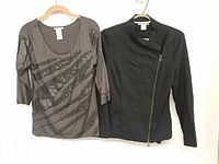 Front view of both garments hanging: grey blouse left, black blazer right