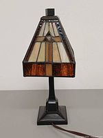 Front view of stained glass table lamp showing geometric shade and metal base