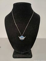 Full view of necklace on display bust showing pendant and chain length