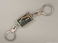 Front view of keychain showing stylized profile inlay