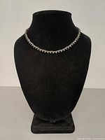 Necklace displayed on black bust showing full frontal view