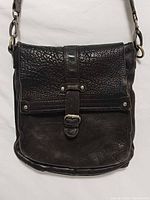 Front view showing pebbled flap, buckle detail, leather texture