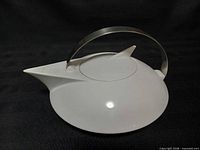 Side view showing spout, lid, and handle