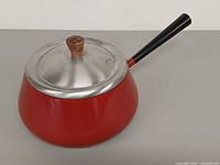 Red enamelware fondue pot angled view