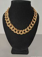 Front view of entire gold-tone Cuban curb chain necklace on display bust