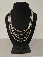 Necklace displayed on bust showing four layered strands
