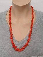 Front view of red branch coral necklace displayed on mannequin showing full length and bead style