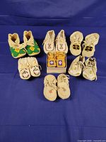 All seven pairs of moccasins arranged to show beadwork and sizes